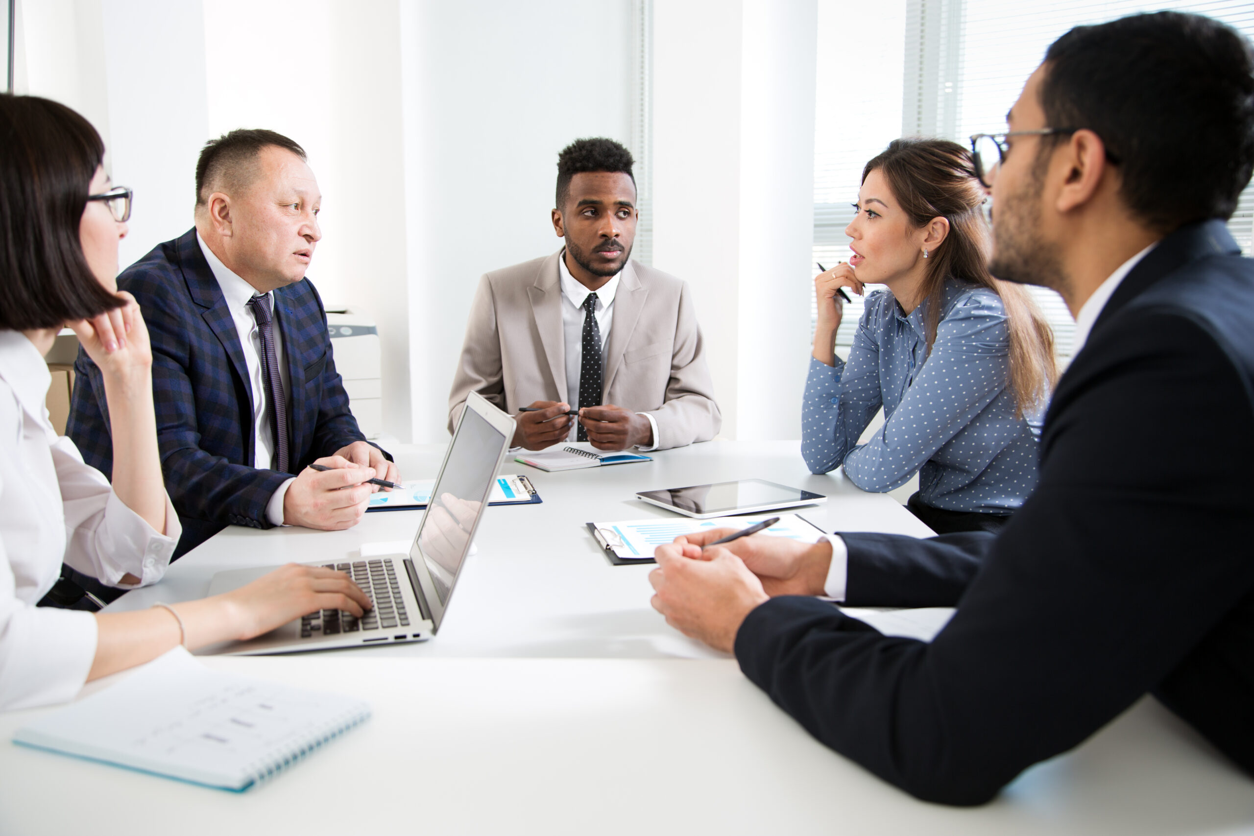 A diverse team of higher education consultants at AHEG collaborating on strategic planning and governance in a professional office setting.